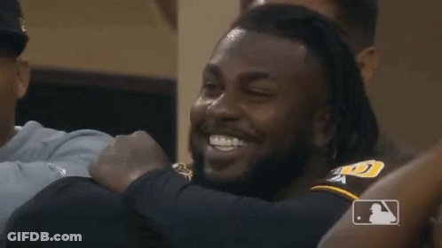 A Group Of Baseball Players Are Hugging And Smiling GIF