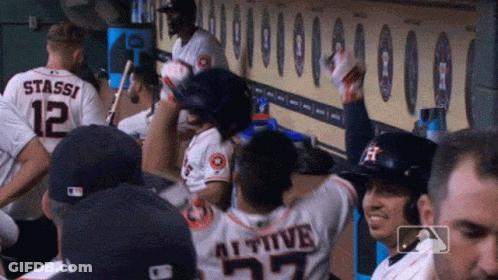 A Group Of Baseball Players Are Sitting In A Dugout And One Of Them Has The Number 27 On His Back GIF