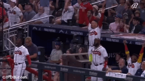 A Group Of Baseball Players Are Standing In A Dugout With A Banner That Says Proud Partner GIF