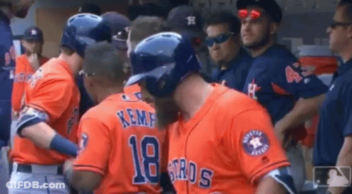 A Group Of Baseball Players Are Standing In The Dugout . GIF