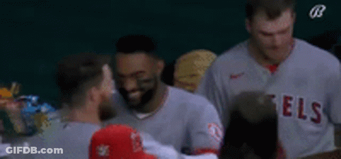 A Group Of Baseball Players Are Standing Next To Each Other On The Field . GIF
