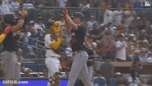 A Group Of Baseball Players Are Standing On A Field Holding Their Bats In The Air . GIF