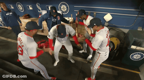 A Group Of Baseball Players In A Dugout One Of Whom Is Wearing A Jersey With The Number 33 On It GIF