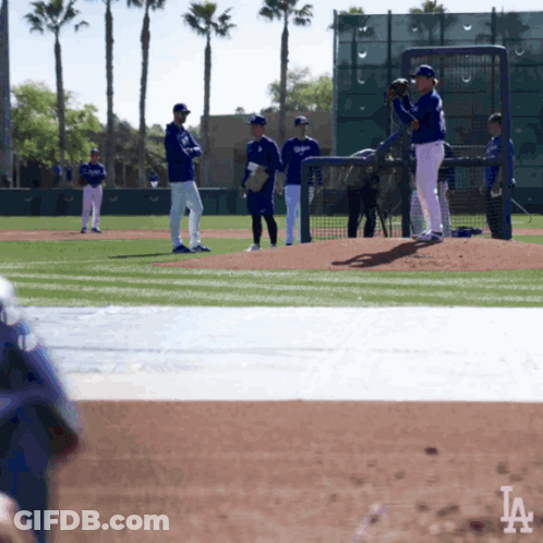 A Group Of Baseball Players On A Field With The La Logo In The Background GIF