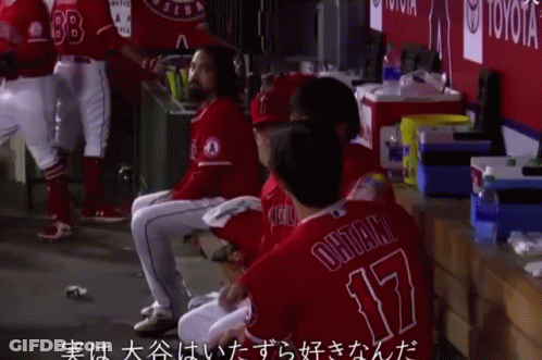 A Group Of Baseball Players Sitting In A Dugout With One Wearing Number 17 GIF