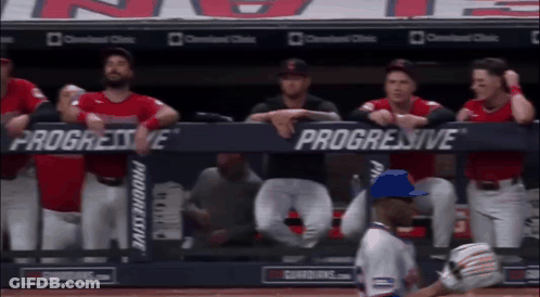 A Group Of Baseball Players Sitting In A Dugout With Progressive Advertisements On The Wall GIF