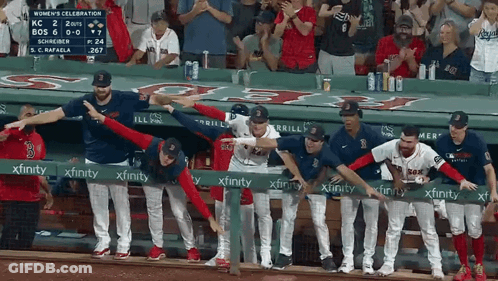 A Group Of Baseball Players Standing Behind A Green Xfinity Sign GIF