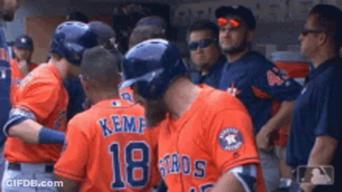 A Group Of Baseball Players Wearing Orange Jerseys With The Number 18 On Them GIF