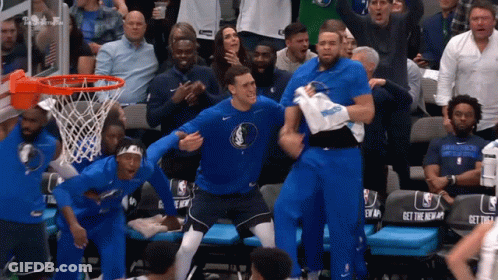 A Group Of Basketball Players Are Celebrating In Front Of A Crowd With A Seat That Says Get The New GIF