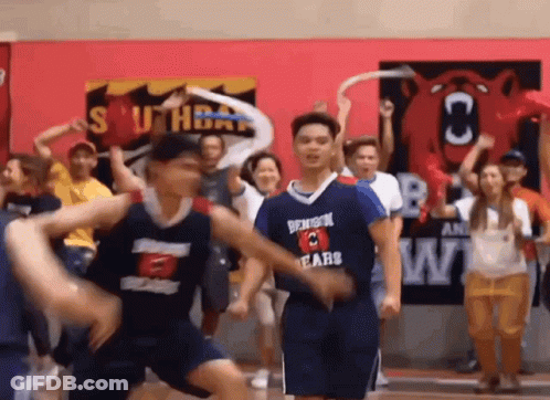 A Group Of Basketball Players Are Dancing On A Court While A Crowd Watches . GIF