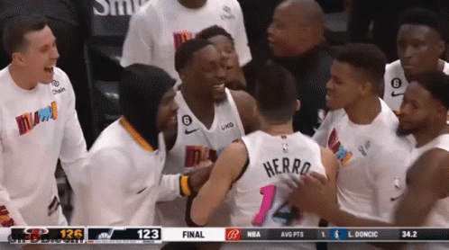 A Group Of Basketball Players Are Gathered Around A Player With The Name Herro On The Back Of His Jersey GIF