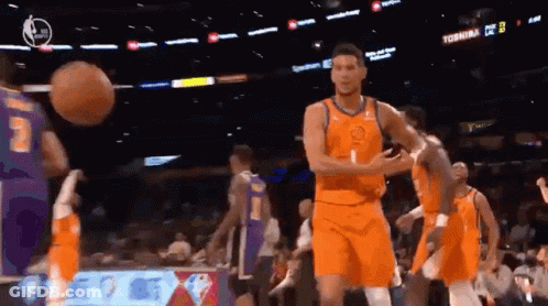 A Group Of Basketball Players Are Playing A Game In A Stadium . GIF
