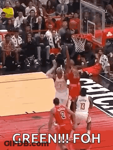 A Group Of Basketball Players Are Playing A Game Of Basketball And One Of Them Is Jumping For The Ball . GIF