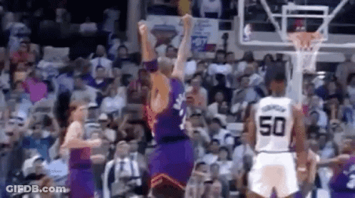 A Group Of Basketball Players Are Playing A Game Of Basketball In A Stadium . GIF