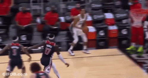 A Group Of Basketball Players Are Playing A Game Of Basketball On A Court In Front Of A Crowd . GIF
