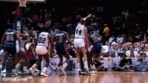 A Group Of Basketball Players Are Playing A Game Of Basketball On A Court In Front Of A Crowd . GIF