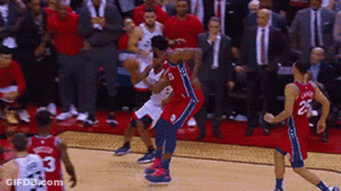 A Group Of Basketball Players Are Playing A Game Of Basketball On A Court In Front Of A Crowd . GIF