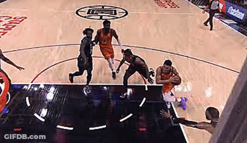 A Group Of Basketball Players Are Playing A Game Of Basketball On A Court With A Logo On The Floor . GIF