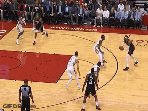 A Group Of Basketball Players Are Playing A Game Of Basketball On A Court With A Referee Watching . GIF