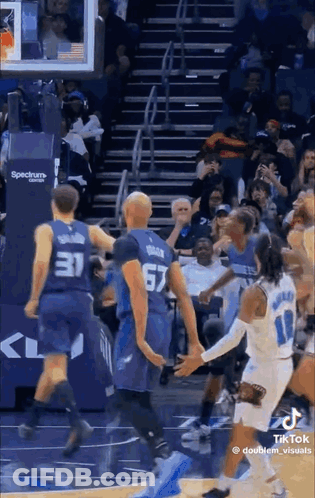 A Group Of Basketball Players Are Playing A Game On A Court . GIF