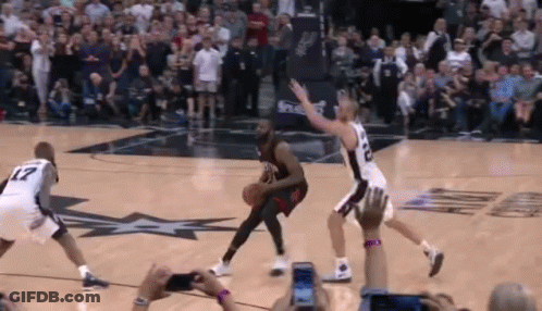 A Group Of Basketball Players Are Playing A Game On A Court With A Crowd Watching . GIF