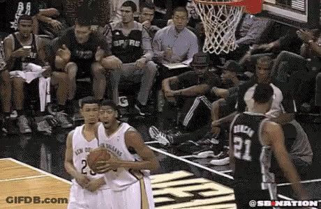 A Group Of Basketball Players Are Playing A Game On A Court With A Crowd Watching . GIF