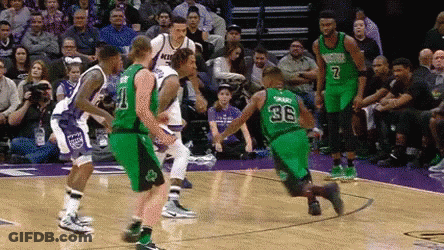 A Group Of Basketball Players Are Playing A Game On A Court With A Crowd Watching . GIF