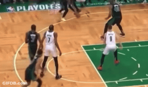 A Group Of Basketball Players Are Playing A Game On A Court With A Sign That Says Playoffs In The Background GIF
