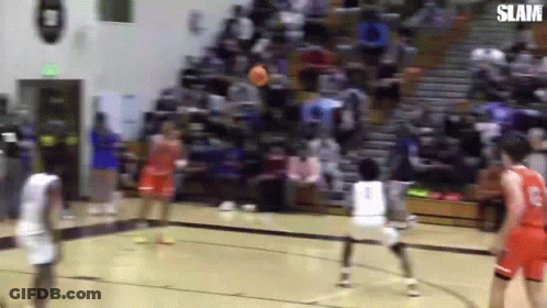 A Group Of Basketball Players Are Playing Basketball On A Court . GIF