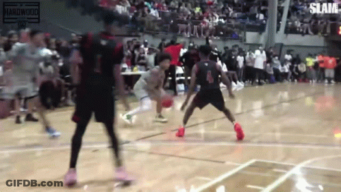 A Group Of Basketball Players Are Playing Basketball On A Court In Front Of A Crowd . GIF