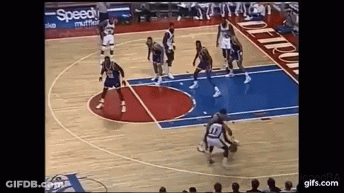 A Group Of Basketball Players Are Playing Basketball On A Court . GIF