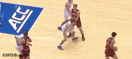A Group Of Basketball Players Are Playing On A Court With A Banner That Says Acc On It . GIF