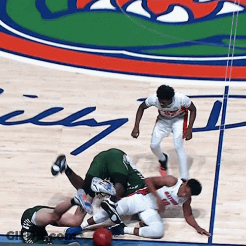A Group Of Basketball Players Are Playing On A Court With The Word Gators On It GIF