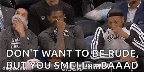 A Group Of Basketball Players Are Sitting In A Stadium Covering Their Noses . GIF