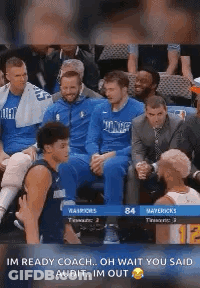A Group Of Basketball Players Are Sitting In A Stadium Watching A Game . GIF