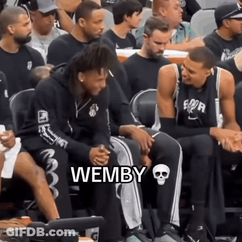 A Group Of Basketball Players Are Sitting In The Stands And One Of Them Is Wearing A Hoodie That Says Wemby GIF