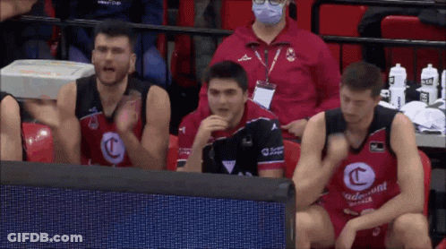 A Group Of Basketball Players Are Sitting In The Stands Wearing Red And Black Jerseys With The Letter C On The Front GIF