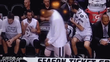 A Group Of Basketball Players Are Sitting On A Bench With A Sign That Says Season Ticket On It GIF