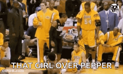A Group Of Basketball Players Are Sitting On The Bench Watching A Game And One Of Them Is Laying On The Floor . GIF