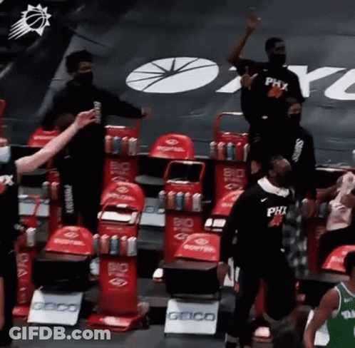 A Group Of Basketball Players Are Standing In A Stadium . GIF