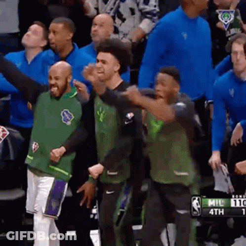 A Group Of Basketball Players Are Standing In A Stadium . GIF