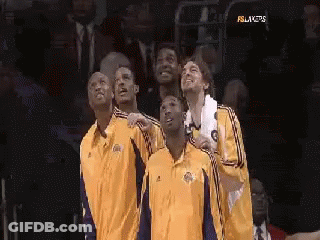 A Group Of Basketball Players Are Standing Next To Each Other In A Stadium . GIF
