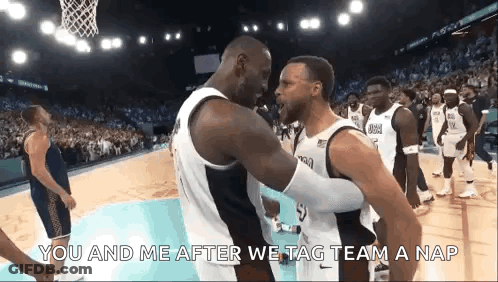 A Group Of Basketball Players Are Standing On A Court And One Of Them Is Hugging Another Player . GIF