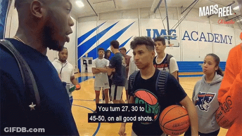 A Group Of Basketball Players Are Standing On A Court In Front Of A Sign That Says Mars Reel GIF