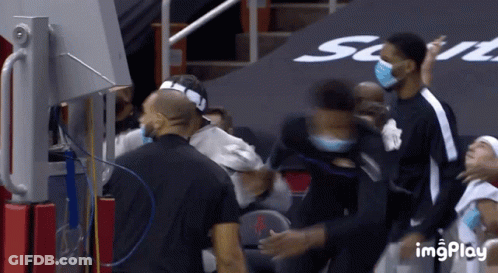 A Group Of Basketball Players Wearing Face Masks Are Standing In A Stadium GIF