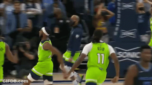 A Group Of Basketball Players Wearing Green Uniforms Are Playing A Game . GIF
