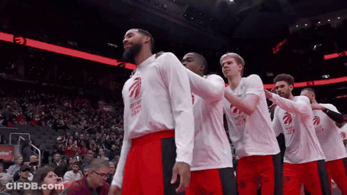 A Group Of Basketball Players Wearing Toronto Raptors Shirts Stand In A Row GIF
