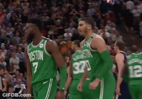 A Group Of Boston Celtics Players Are Standing On The Court During A Game . GIF