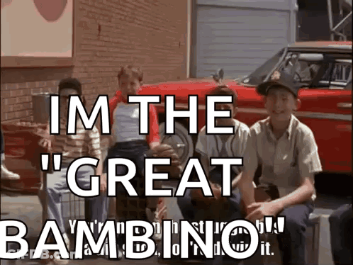 A Group Of Boys Are Sitting In Front Of A Red Car With The Words " Im The Great Bambino " GIF