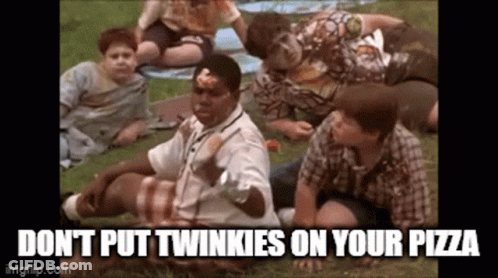A Group Of Boys Are Sitting On The Grass Eating Pizza And A Man Is Holding A Pizza In His Hand . GIF